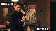 two men are hugging each other in a room with the words robert and kemal on the bottom