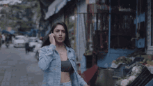 a woman in a denim jacket is talking on a cellphone
