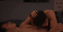 two naked men are laying on a bed with their heads on each other 's chests