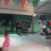 a little girl in a pink dress is dancing on a white floor