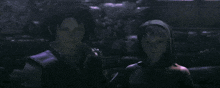 a man and woman are standing next to each other in a dark room