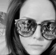 a woman wearing sunglasses with the word koda on the lenses