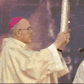 a man in a purple hat is holding a large object in his hands