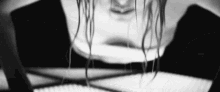 a black and white photo of a woman 's face with long hair .