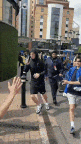 a group of people walking down a street in front of a building that says ' the club '