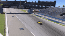 a yellow race car is driving down a race track with a sign that says nvidia on it