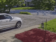 a white car is parked on the side of the road in front of a house