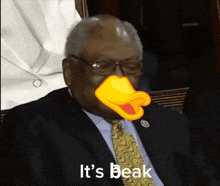 a man in a suit and tie with a yellow duck 's beak on his face