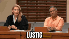 a judge and a man are sitting at a table in a courtroom with a sign that says lustig .