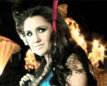 a woman in a blue dress is holding a microphone in her hand
