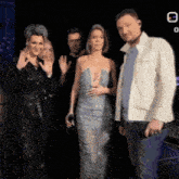 a group of people are posing for a picture and one of them is wearing a dress