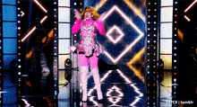 a woman in a pink dress and pink boots is dancing on a stage
