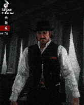a man wearing a hat and vest is sitting in front of a window .