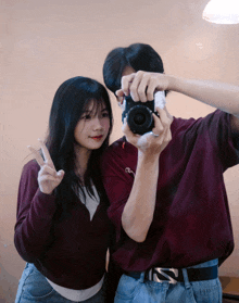 a man is taking a picture of a girl with a canon camera