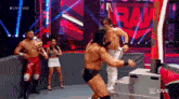 a group of men are wrestling in a wrestling ring while a woman watches .