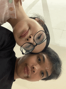 a man and a woman wearing glasses are posing for a photo