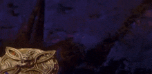 a gold ring with a celtic design is sitting on a purple and blue background .