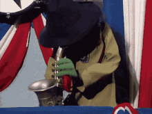a person in a black hat is playing a saxophone in front of a red white and blue curtain