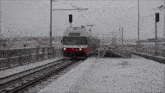 a red and white train is on the tracks with a sign that says ' stop ' on it