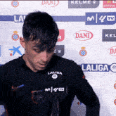 a man stands in front of a wall with laliga logos