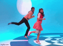 a boy and a girl are running on a checkered floor