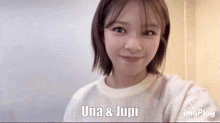 a woman in a white sweater is smiling with the words una & jupi behind her