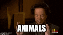 a man in a suit and tie is talking about animals