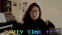 a girl with glasses is standing in front of a piano with the words party time written on the screen behind her