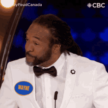 a man in a white suit has a name tag with the name wayne on it