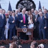 a group of people posing for a picture with donald trump