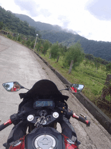 a motorcycle is parked on the side of a road with a mountain in the background