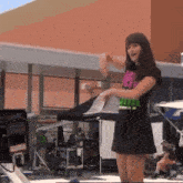 a woman wearing a black skirt and a pink and green shirt that says ' i 'm a bitch '