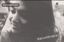 a black and white photo of a man and a woman looking at each other .