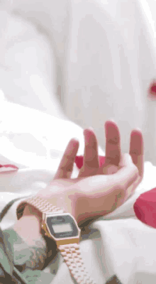 a person laying on a bed wearing a watch