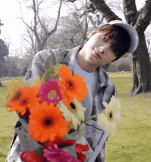 a man in a baseball cap holds a bouquet of flowers