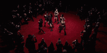 a group of people are dancing in a dark room and one of them has the number 23 on their shirt