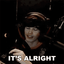 a man wearing headphones says it 's alright in a dark room .