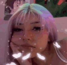 a girl with purple hair is making a face with her hand on her chin .