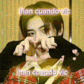 a man in a plaid shirt is making a heart shape with his hands and the words than cuando vic are above him .