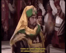 a man with a beard is wearing a turban and a yellow and green shawl .