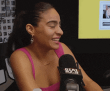 a woman sitting in front of a microphone that says beat 92.9