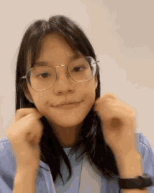 a young girl wearing glasses and a watch makes a funny face