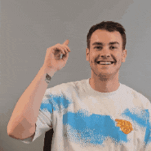 a man wearing a blue and white shirt is smiling and giving a thumbs up
