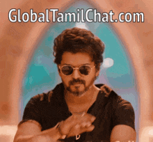a man wearing sunglasses and a black shirt with the website global tamilchat.com written below him