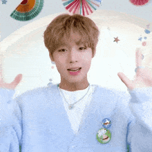 a young man wearing a light blue cardigan has a badge on his back that says " i love you "