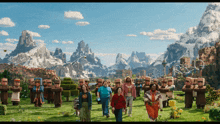 a group of people are walking in a field with a mountain in the background
