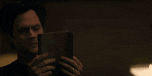 a man is walking in a dark room with a lamp in the background .