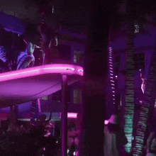 a woman in a blue bikini is standing on top of a purple slide