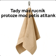 a tan towel is hanging on a hook with the words tady mas ruchnik protoze moc potis atitank written above it