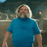 a man with long hair and a beard is wearing a blue shirt that says i am hungry